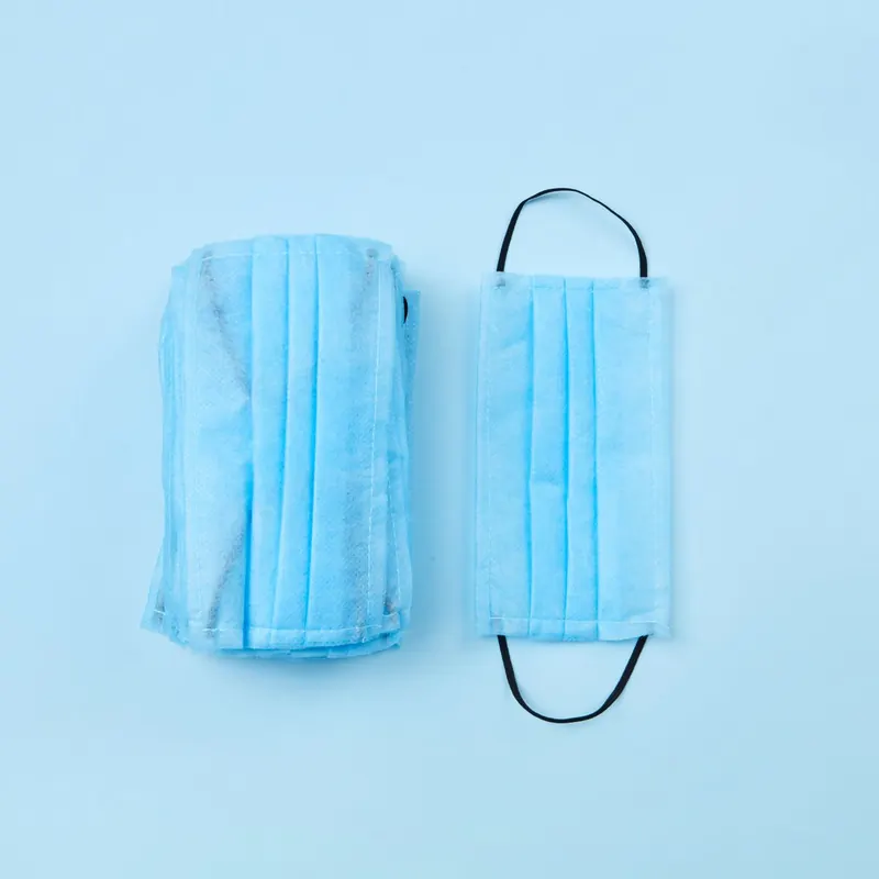 Máscaras descartáveis sobre fundo azul claro
